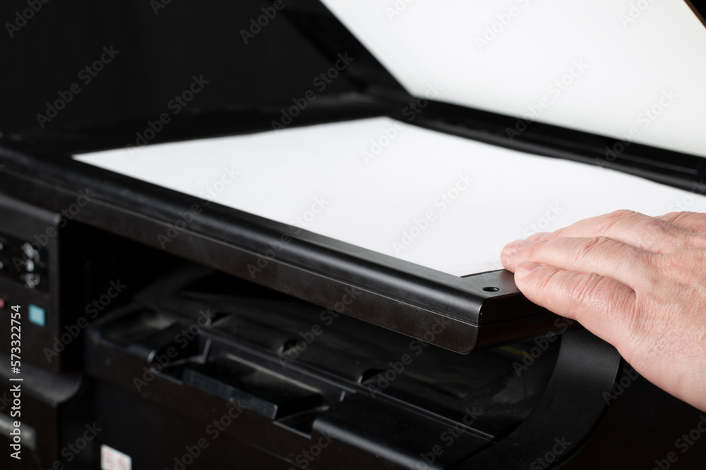 Printer and scanner on a dark background.Combo.A person uses a scanner to work. Printer and scanner on a dark background.Combo.A person uses a scanner to work.
