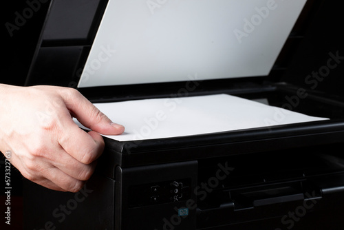 Printer and scanner on a dark background.Combo.A person uses a scanner to work.