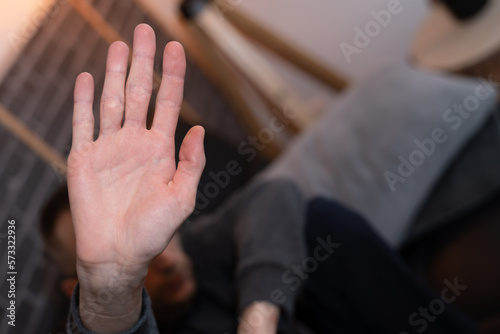 jeune homme accroupis victime de harcèlement se protégeant de sa main photo