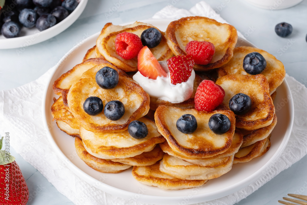 Homemade mini pancakes with blueberries, strawberries and raspberries Homemade mini pancakes with blueberries, strawberries and raspberries