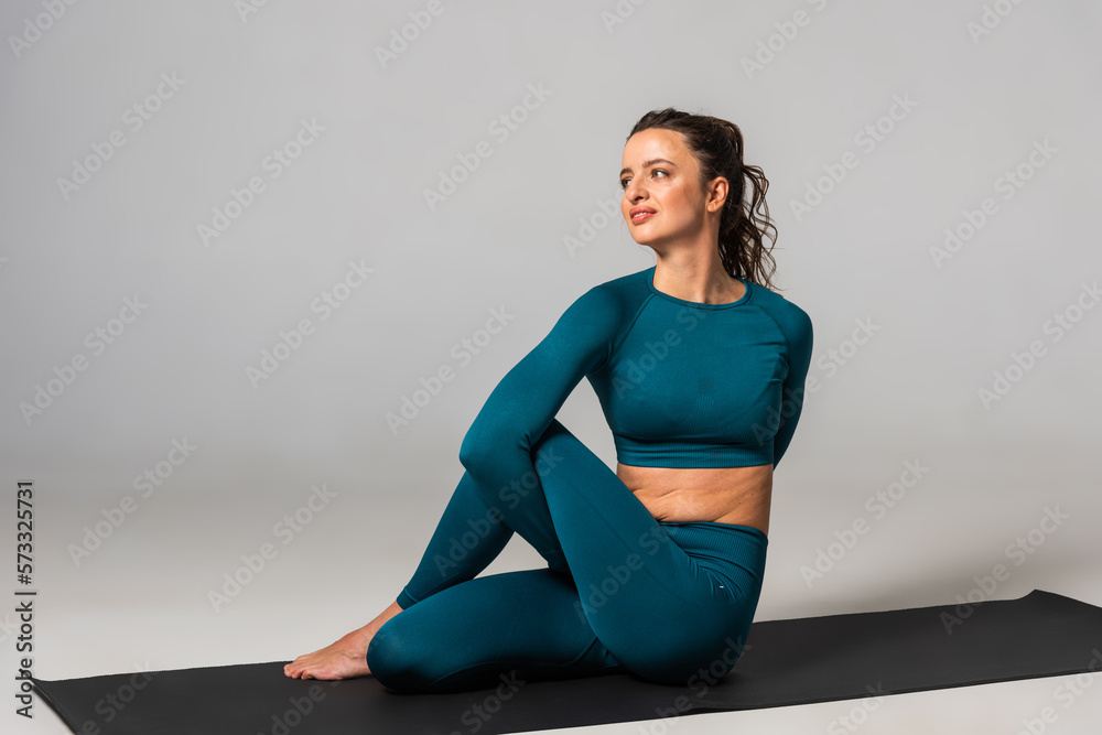 Fototapeta premium A beautiful woman is exercising in a yoga class for weight loss