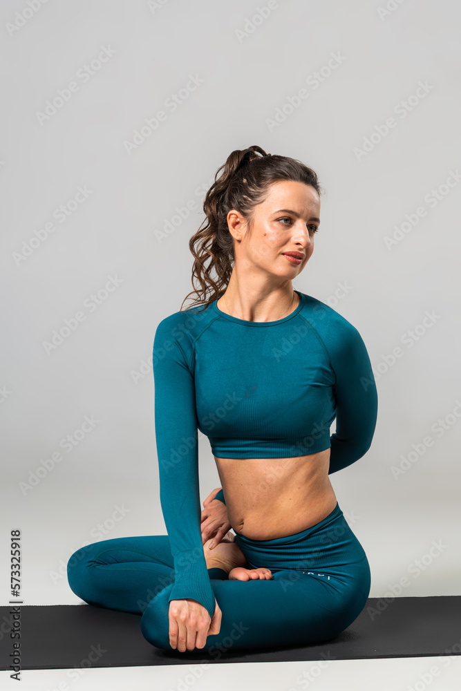 Fototapeta premium A beautiful woman is exercising in a yoga class for weight loss