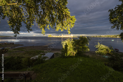 View of the Neva and the Oreshek (Shlisselburg) Fortress, on a cloudy day illuminated by the sun