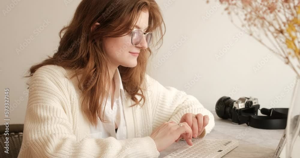 Close up of female photographer working on tablet with keyboard at the table with camera on background in the studio Close up of female photographer working on tablet with keyboard at the table with camera on background in the studio