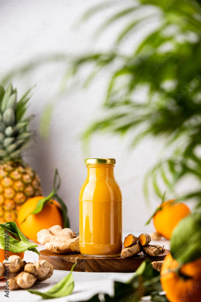 Φωτογραφία Fresh raw ingredients for detox ginger and curcumin smoothies and already blended mix in a bottles for individual consumption are on the kitchen table surface