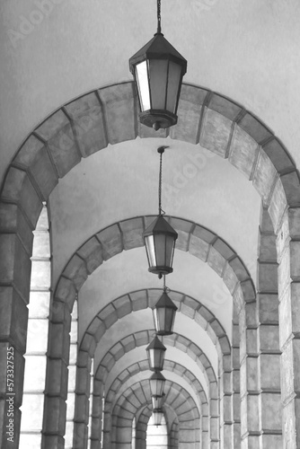 The arched stone colonnade with lanterns concept photo. Urban architectural photography.