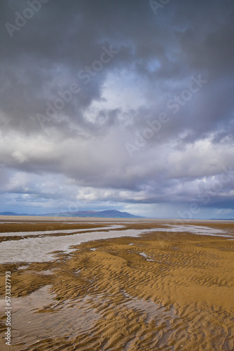 Cloudy sky over a sandy beach at low tide photo