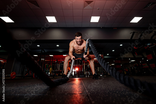 Training muscular male person in the gym. Young male athletic man working out in gym. © Vadim
