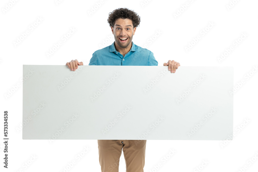excited casual guy with curly hair laughing and holding empty board excited casual guy with curly hair laughing and holding empty board