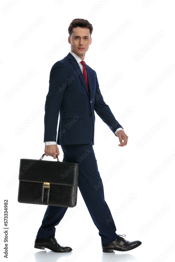 businessman walking and holding a briefcase to the side businessman walking and holding a briefcase to the side