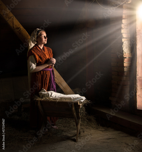 Obraz na plátně Mary sits in the stable near the manger with the baby