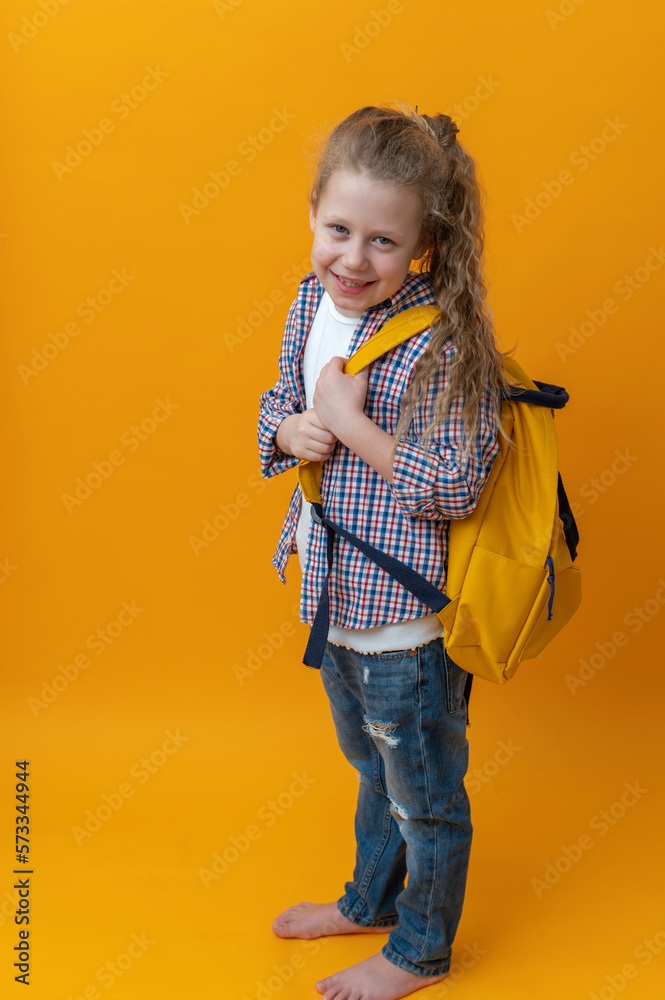 back to school, cute joyful girl child 6-7 years old smiling on an isolated yellow background in with a school backpack. High quality photo back to school, cute joyful girl child 6-7 years old smiling on an isolated yellow background in with a school backpack. High quality photo