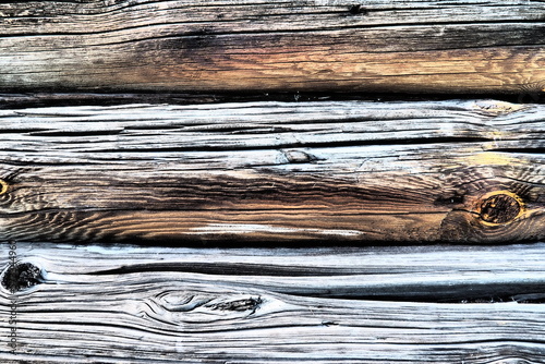 Background horizontal logs. Wooden background from shabby boards and logs. Round lumber assortment. General purpose lumber. Special type of forest products. Knots and branches.