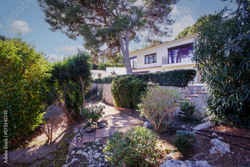 Family home on its own land, pine trees, hedges, tiled walkways. photo