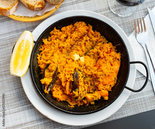 Spain's national dish, paella de marisco, served on plate. Boiled rice with seafood.