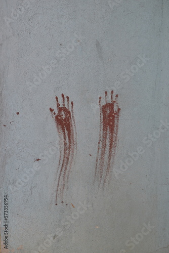 Two bloody hands asking for help symbol painted with red on a wall