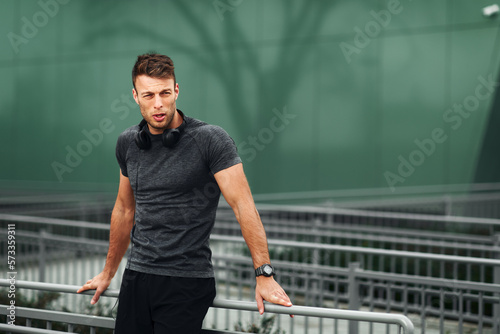 Attractive sport man take a break after jogging outdoor