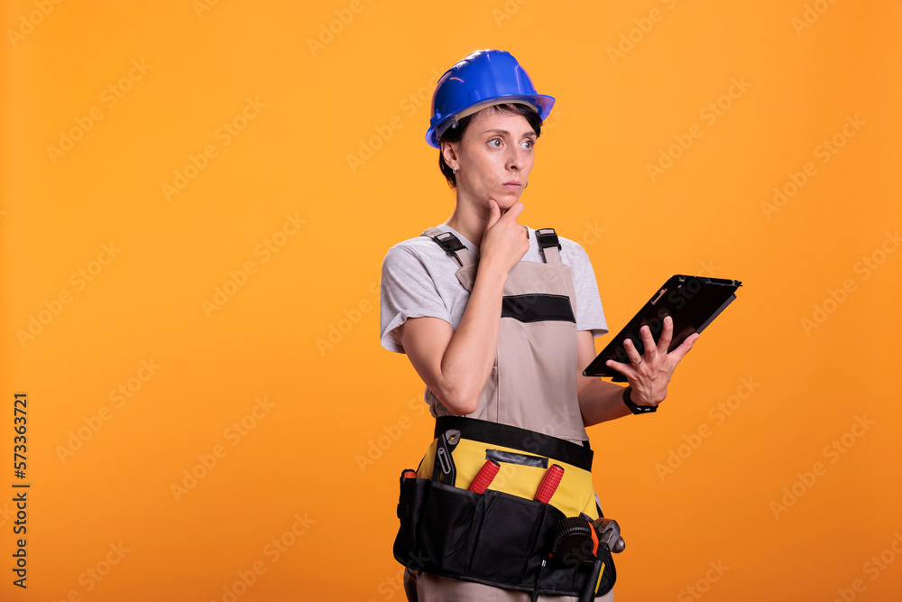 Female contractor with digital tablet browsing internet app, searching for building project on website. Construction worker using portable gadget with wireless network, industrial skill.