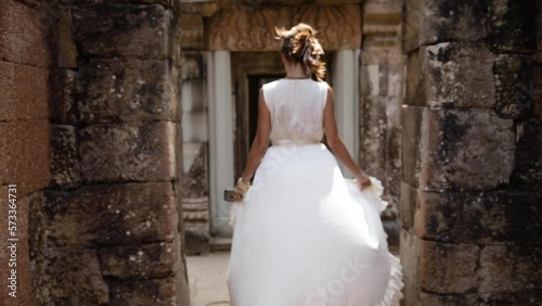 Woman walking through ancient ruins of Angkor wat in Siem Reap, Cambodia