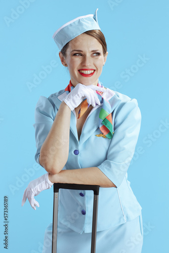 happy elegant flight attendant woman on blue looking aside
