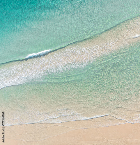 Aerial view of a beach with idyllic tropical blue water and gentle waves 