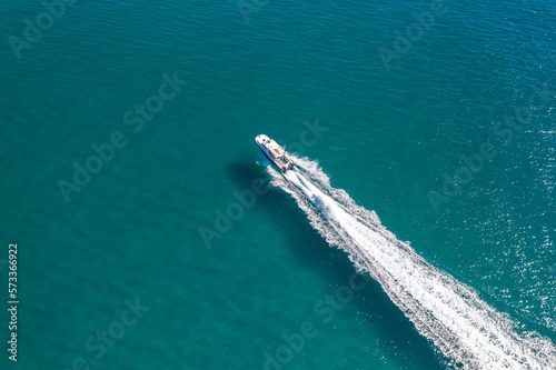 Aerial view of a boat speeding through stunning blue water