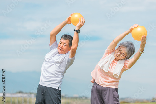 ボールを使って体操をする高齢者夫婦  © buritora