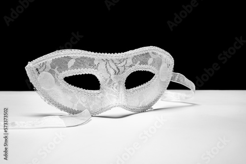 White lace-like fabric mask on smooth white surface