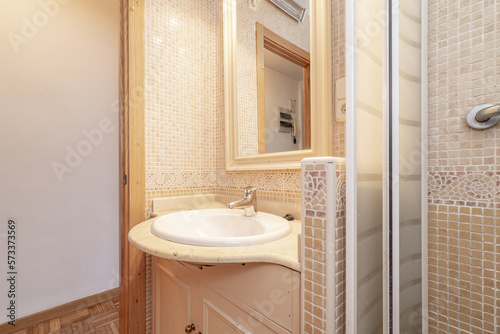 Bathroom with cream marble top and mirror with wooden frame and shower tray with gresite tile and oak door frames