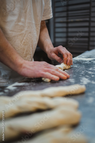 Baker rolling up stuffed bread sticks in a artisan bakery
