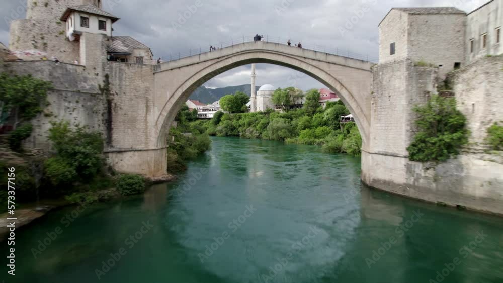 Aerial flight under famous old bridge in Mostar, popular touristtic destination in Bosnia and Herzegovina Aerial flight under famous old bridge in Mostar, popular touristtic destination in Bosnia and Herzegovina