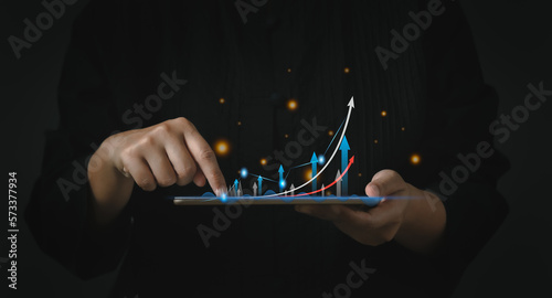Startup business concept. Business people touching on tablet with icon business and network connection on modern virtual interface from digital tablet on dark background.