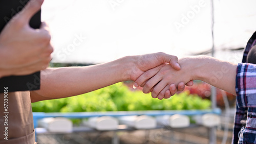 Close-up image of a successful farm owner shaking hand with a farmer or supplier, dealing business photo