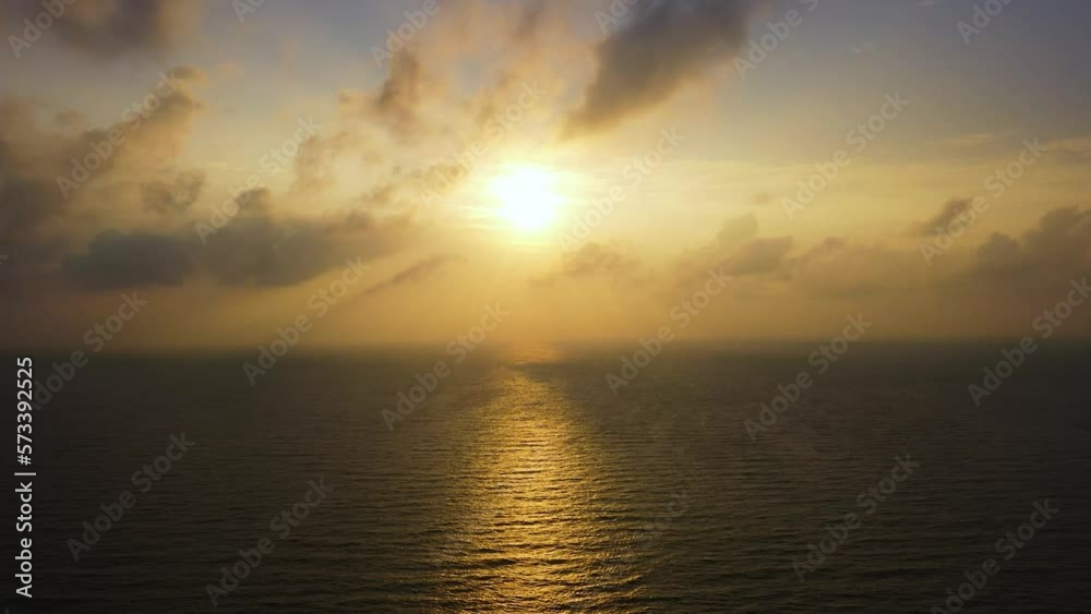 Aerial view of golden sky over the sea and reflection at sunset.