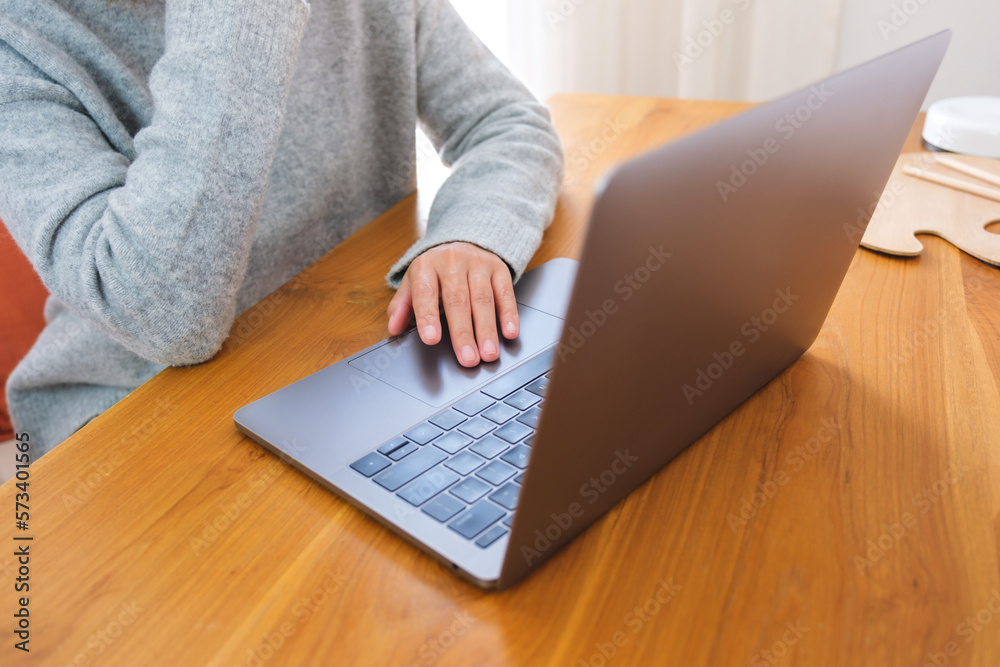Fototapeta premium Closeup image of a woman working on laptop computer touchpad