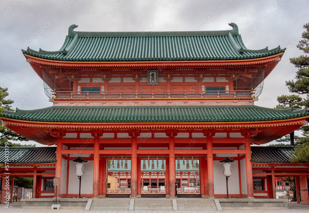 Colorful orange buddhist temple building pagoda structure at Heian Heritage Cultural Shrine in Kyoto Japan on a cloudy day
