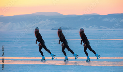 A young happy woman is skating on the transparent ice of the frozen Lake Baikal on a sunny winter day - World-famous figure skater 
