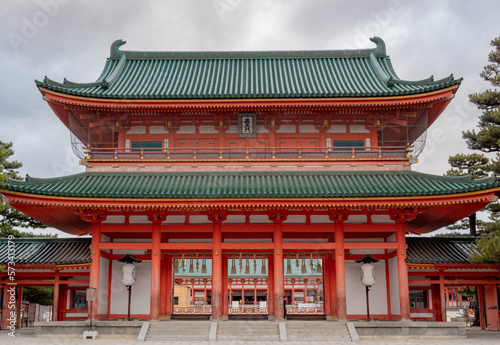 Colorful orange buddhist temple building pagoda structure at Heian Heritage Cultural Shrine in Kyoto Japan on a cloudy day