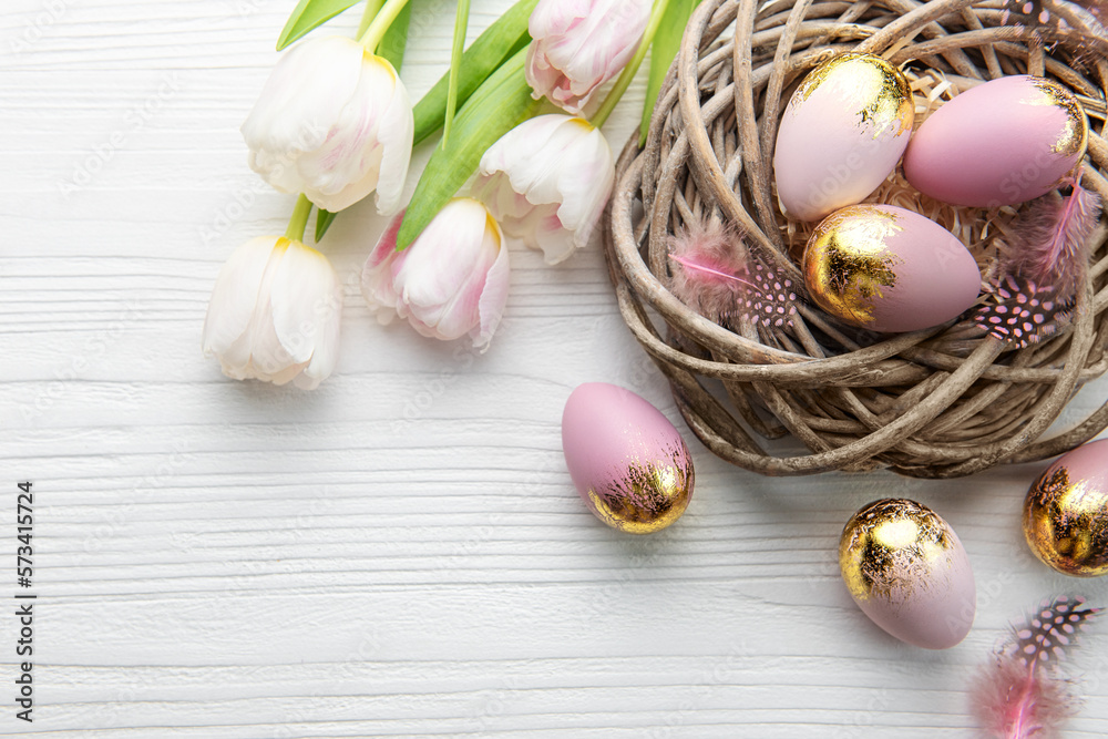 Nest with Easter eggs painted pink and golden colors on a white wooden background. Nest with Easter eggs painted pink and golden colors on a white wooden background.
