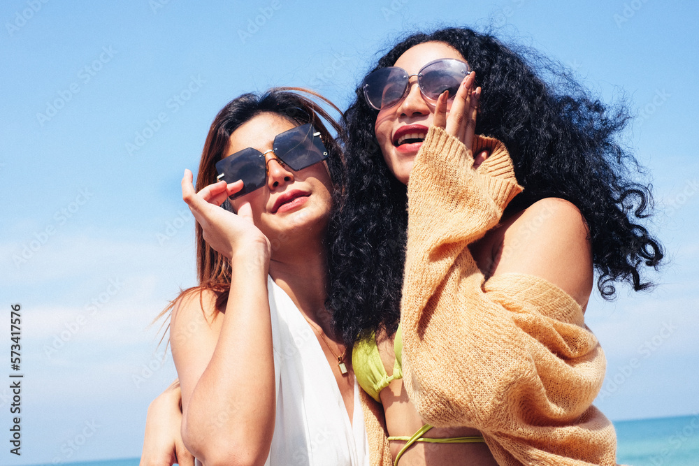 Two Women Enjoying Beach Holiday,Two young female friends hangout at the beach ,enjoying and relaxing in beautiful summer vacation.They hug each other.Best friends. Two Women Enjoying Beach Holiday,Two young female friends hangout at the beach ,enjoying and relaxing in beautiful summer vacation.They hug each other.Best friends.