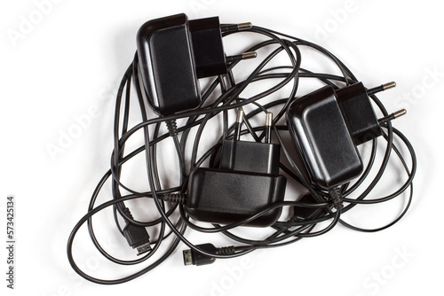 Chargers for phones with tangled wires. Wired chargers on a white background.