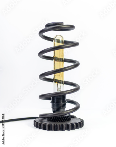 Black spiral lamp with bulb on white background.