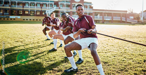 Man, team and sports tug of war with rope for fitness exercise, strength challenge or competition on field. Sport men in rivalry, teamwork struggle or leadership pulling ropes in training activity