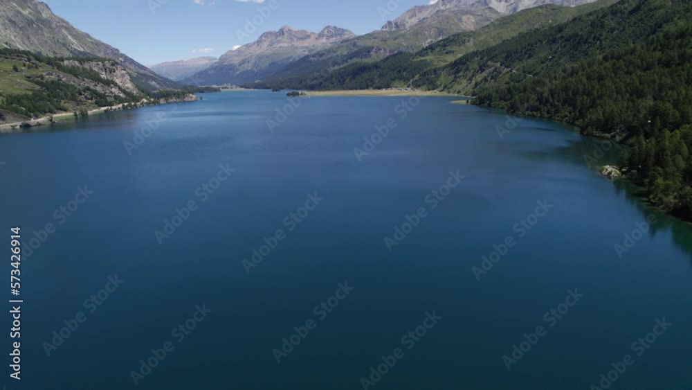 Aerial View Over Calm Lake Silvaplana On Clear Sunny Day. Dolly Back With Tilt Up Shot Aerial View Over Calm Lake Silvaplana On Clear Sunny Day. Dolly Back With Tilt Up Shot