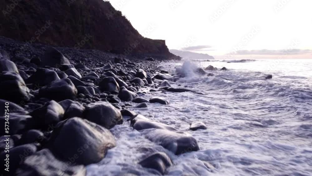 Drone flying low over Volcanic beach, Waves rolling onto black beach pebbles, Madeira Island Drone flying low over Volcanic beach, Waves rolling onto black beach pebbles, Madeira Island