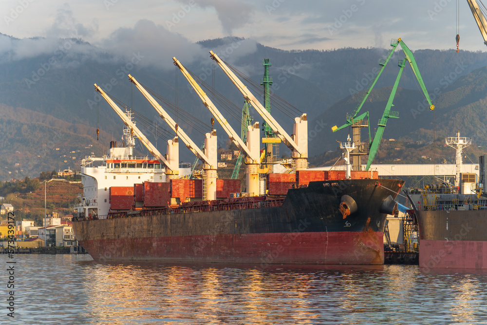 Cargo freight ship in industrial port. Logistics, import and export commerce, international transportation concept.
