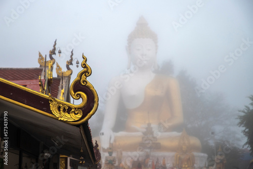 Close up of roof temple at wat Doi khum buddhist statue. Chiang mai, Thailand. .With  the largest bhudda on mist background photo