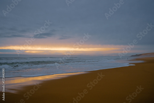 Dramatic sunset on the beach. Wide sandy beach, stormy sea, and beautiful cloudy sky