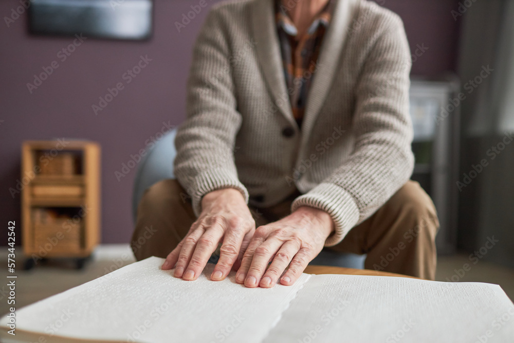 Senior man with disability reading a book in Braille Senior man with disability reading a book in Braille