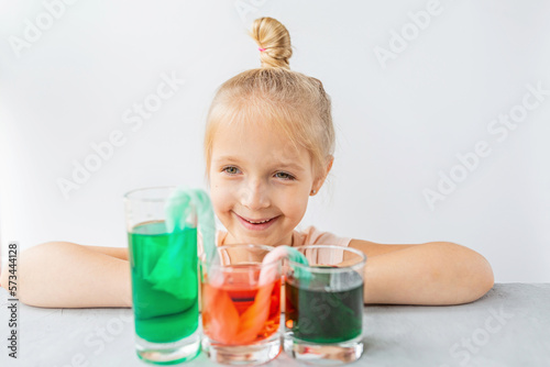 cute little girl six years old doing laboratory experiment with colorful water in classroom. Education science concept. Selective focus. Distance learning during covid-19 coronavirus quarantine.
